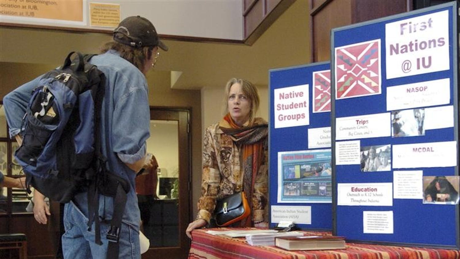 Program Assistant Mary Conners shares information with an attendee of an opening ceremony for National American Indian Heritage Month 
on Wednesday afternoon at the Showers City Hall Atrium.  The event was hosted by Indiana University's First Nations Educational and Cultural Center.
