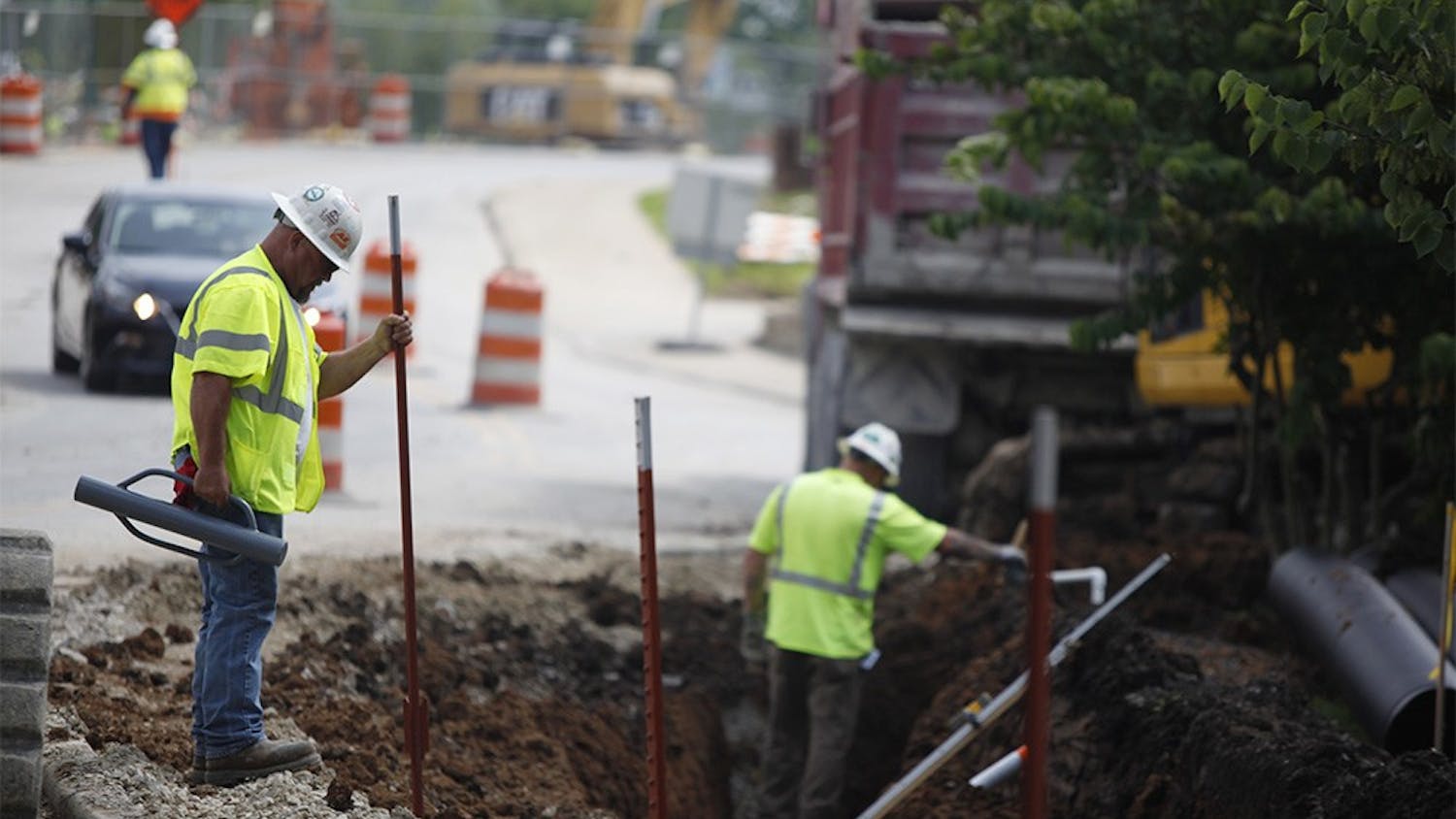 Jeff Gott, a superintendent with Milestone Contractors, drives beams into the ground on Jordan Ave. Wednesday.  Construction has been slowed down by the rain, but construction workers have been working through the rain to get the job done, he said.