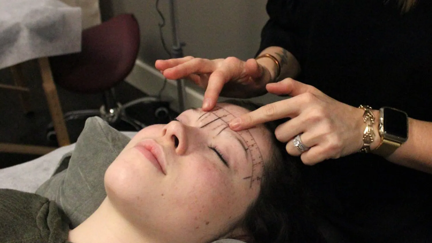 Shaena Litwin, the owner of a microblading studio off North Walnut Street, measures and plans her client's eyebrows on Tuesday. Eyebrows should be sisters, not twins in terms of style, she said.