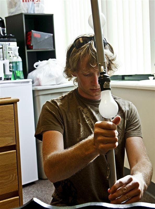 IU senior Andrew Peacock assembles a new lamp fr his room Monday afternoon at Wilkie North. Peacock is one of many upperclassmen who opted to move in early to beat the rush of incoming freshman.