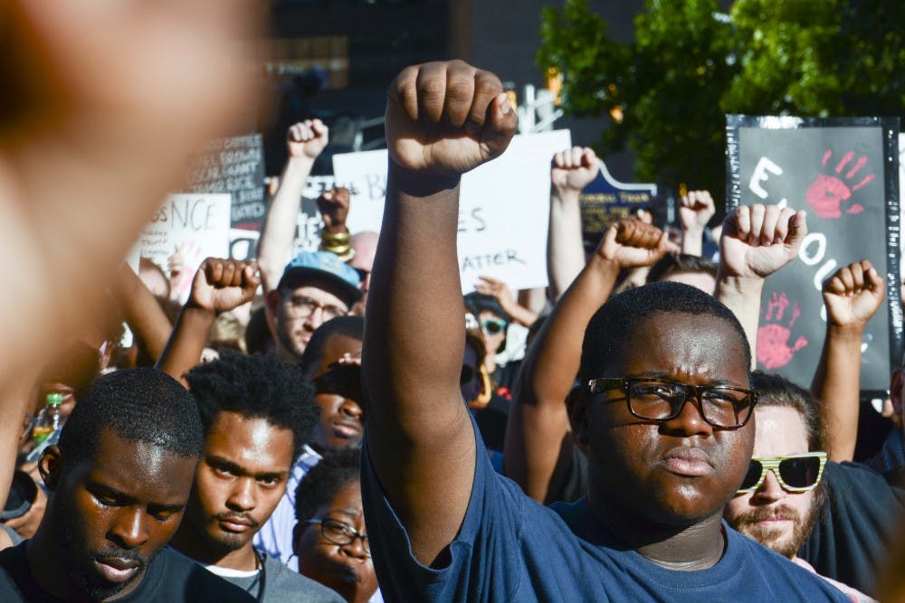 Participants raised a fist as a symbol of solidarity for the Black Lives Matter movement on Saturday evening at the State House, Indianapolis. 