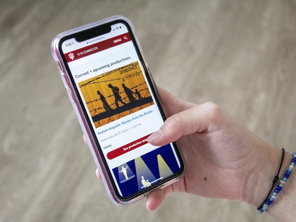 A phone displays the current and upcoming productions for the IU Theatre. The production “Asylum Anguish: Stories from the Border” has been postponed indefinitely due to concerns over inaccurate depictions of characters during casting.