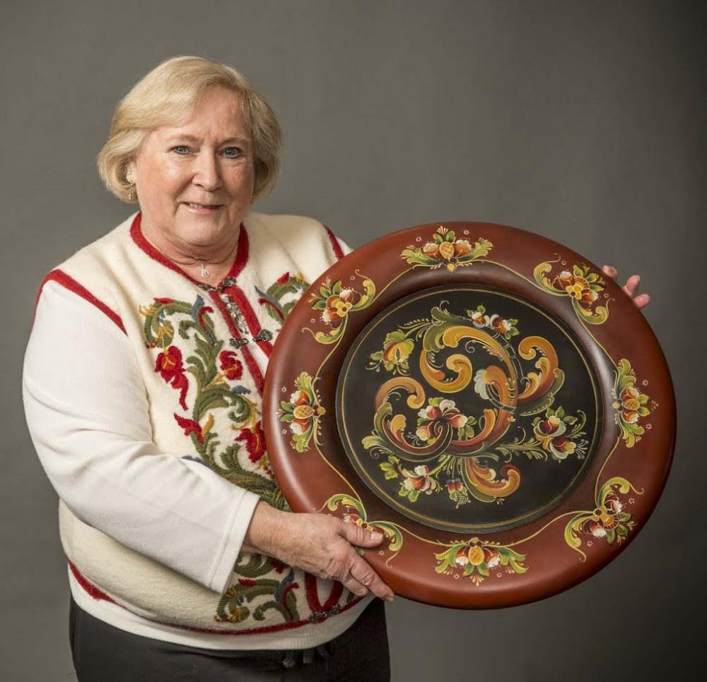 Jan Boettcher with an example of her work with rosemaling, a Norwegian painting technique. Boettcher will be one of two artists demonstrating their craft at the Mathers Museum of World Cultures on Thursday.