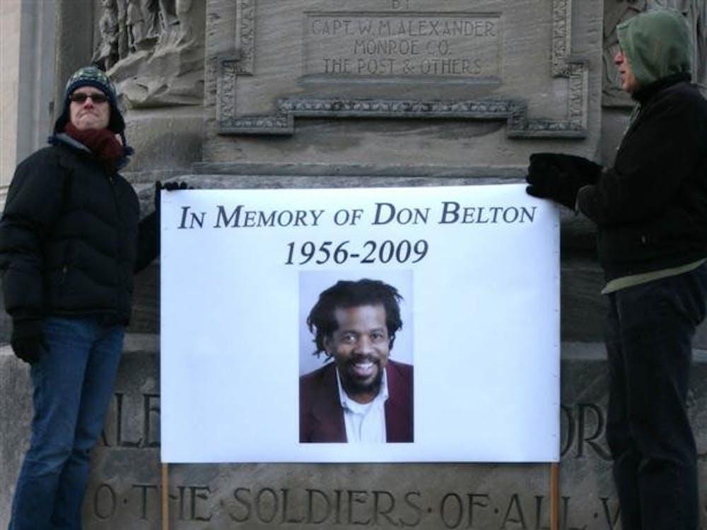 A sign is held on Bloomington's Courthouse Square during a memorial for assistant professor Don Belton, New Year's Day.  Belton, 54, was killed in his home by Michael James Griffin, 26, on Dec. 27, 2009.