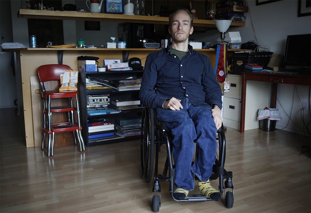 Benedict Jones poses in the living room of his Bloomington apartment Tuesday.  Jones, who is considered a quadriplegic, was accidently shot by a friend at the age of 11.