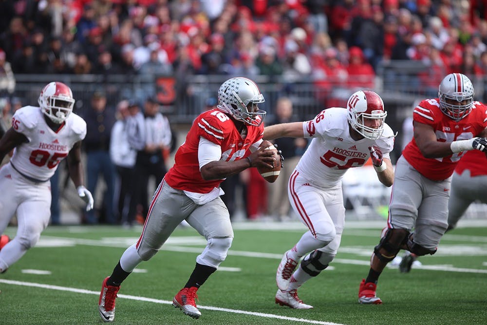 IU defenders chase Ohio State quarterback J.T. Barrett, who looks for an open receiver. The Hoosiers lost to the Buckeyes 42-27 on Saturday.