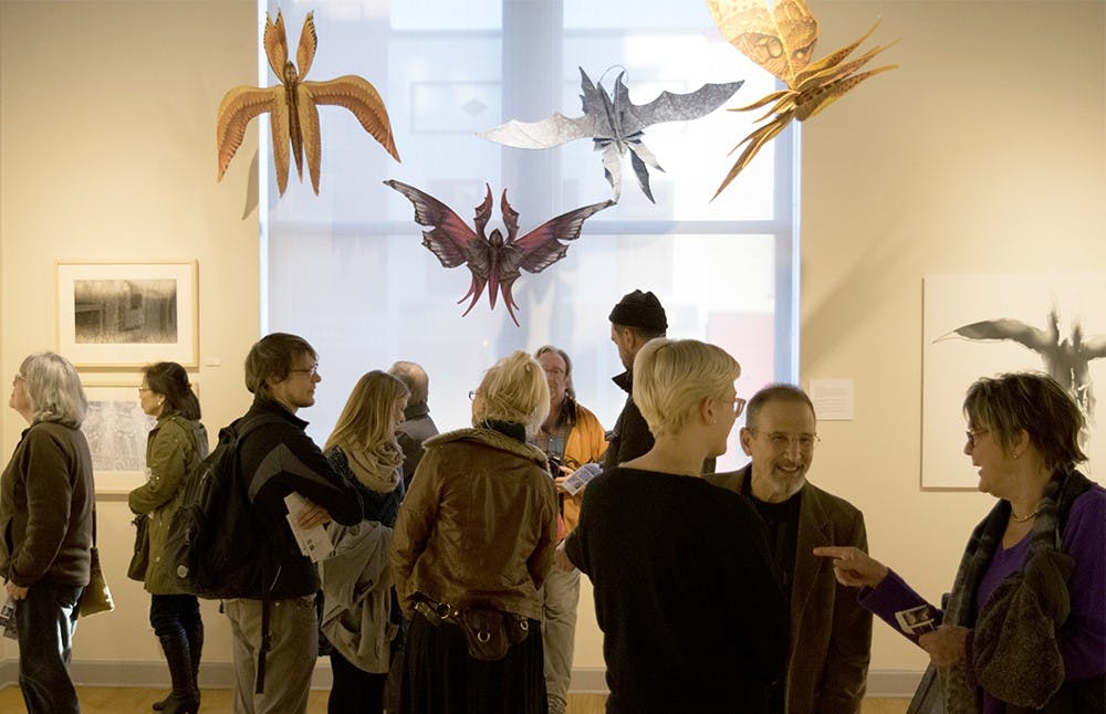 Students and local residents participate in the art exihibation of Ed Bernstein, former IU studio art professor, Friday afternoon at the Ivy Tech Waldron Arts Center. Print works and scluptures were presented in this show. 