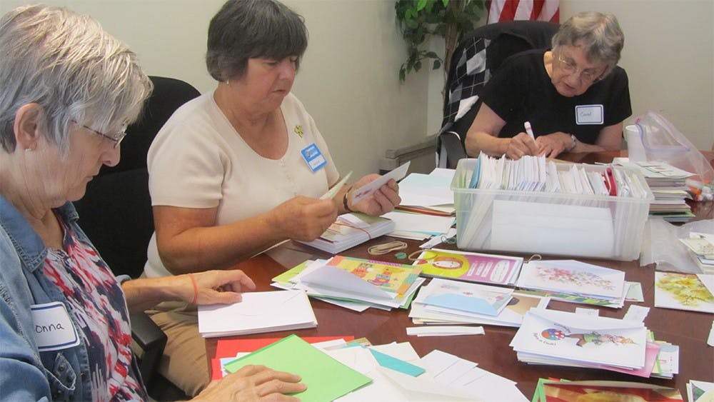 Donna Brinton, Jeane Novotny and Carol Wise sort cards at the new RSVP +55 Volunteer Center Tuesday. 