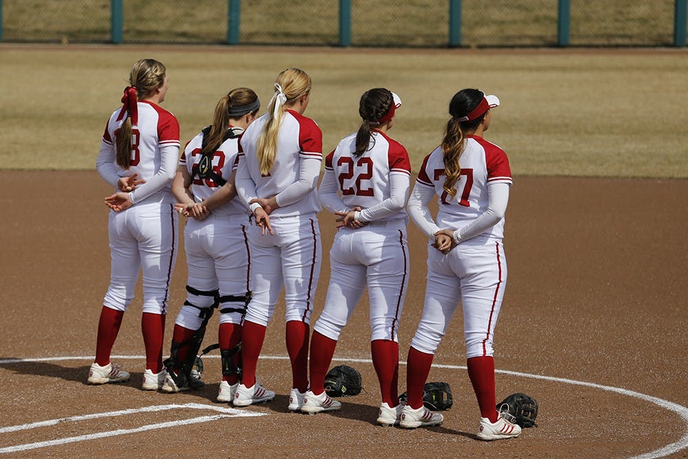 IU Softball Players stand on the field during the singing of the national anthem before their game against Rutgers University on Mar. 22. 