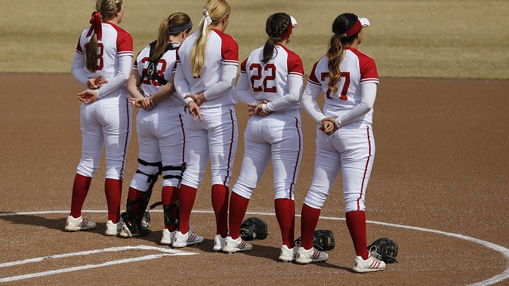 IU Softball Players stand on the field during the singing of the national anthem before their game against Rutgers University on Mar. 22. 