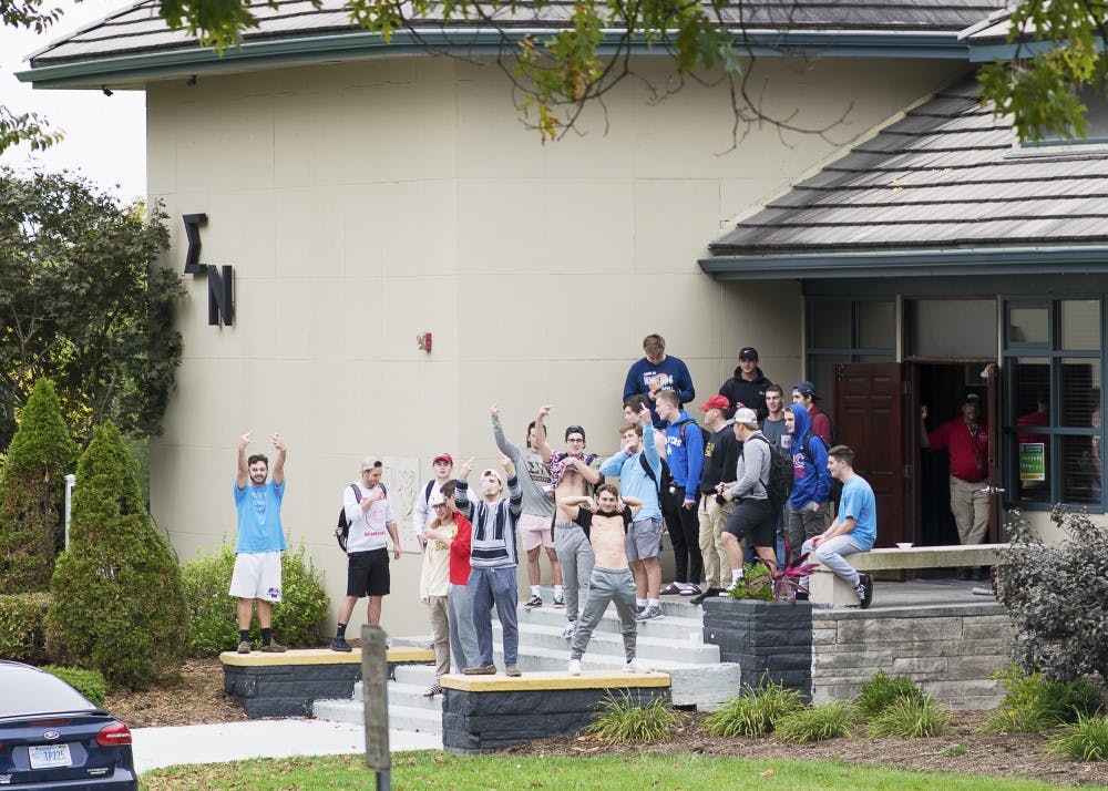 <p>Members of the fraternity Sigma Nu gather on the front porch of their house on North Jordan Avenue on Wednesday afternoon. The Beta Eta chapter of Sigma Nu was suspended from the IU campus by its national leadership due to alleged hazing and alcohol related violations.&nbsp;</p>