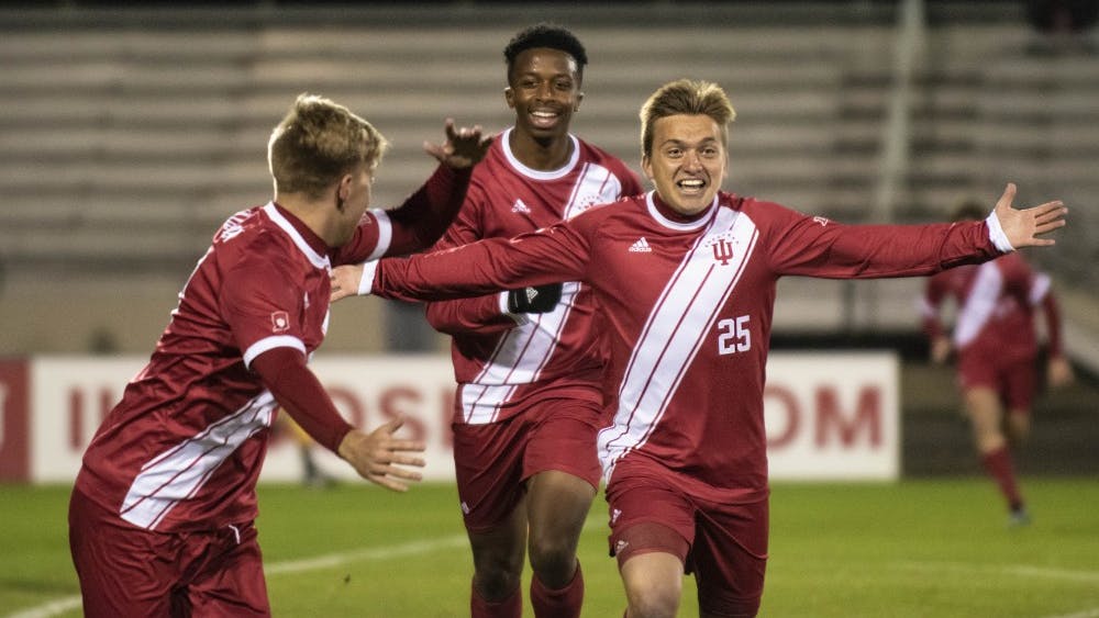 Redshirt freshman Trey Kapsalis, right, celebrates his first goal of the season with freshman Maouloune Goumballe, center, and redshirt sophomore John Bannec, left, on Oct. 22 at Bill Armstrong Stadium. IU defeated the University of Evansville, 5-1.