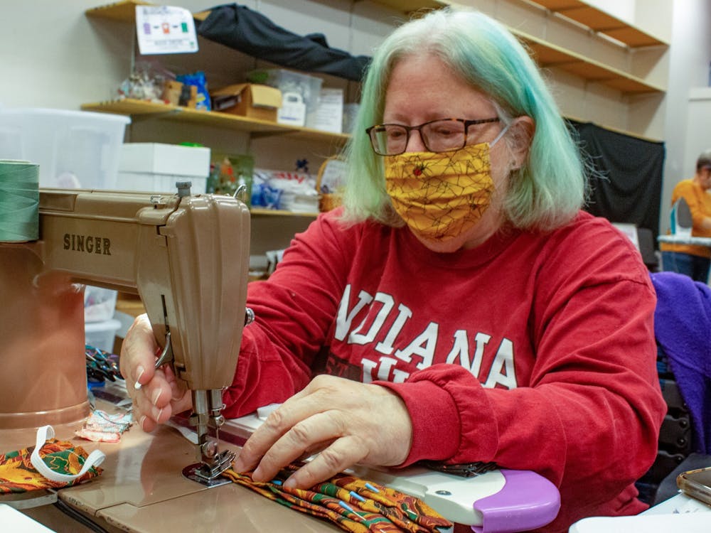Bloomington Mask Drive co-founder Nola Hartman sews elastic ear pieces to mask fabric Oct. 22, 2021, at the College Mall. Hartman teaches volunteers how to sew masks using sewing machines, she said. 