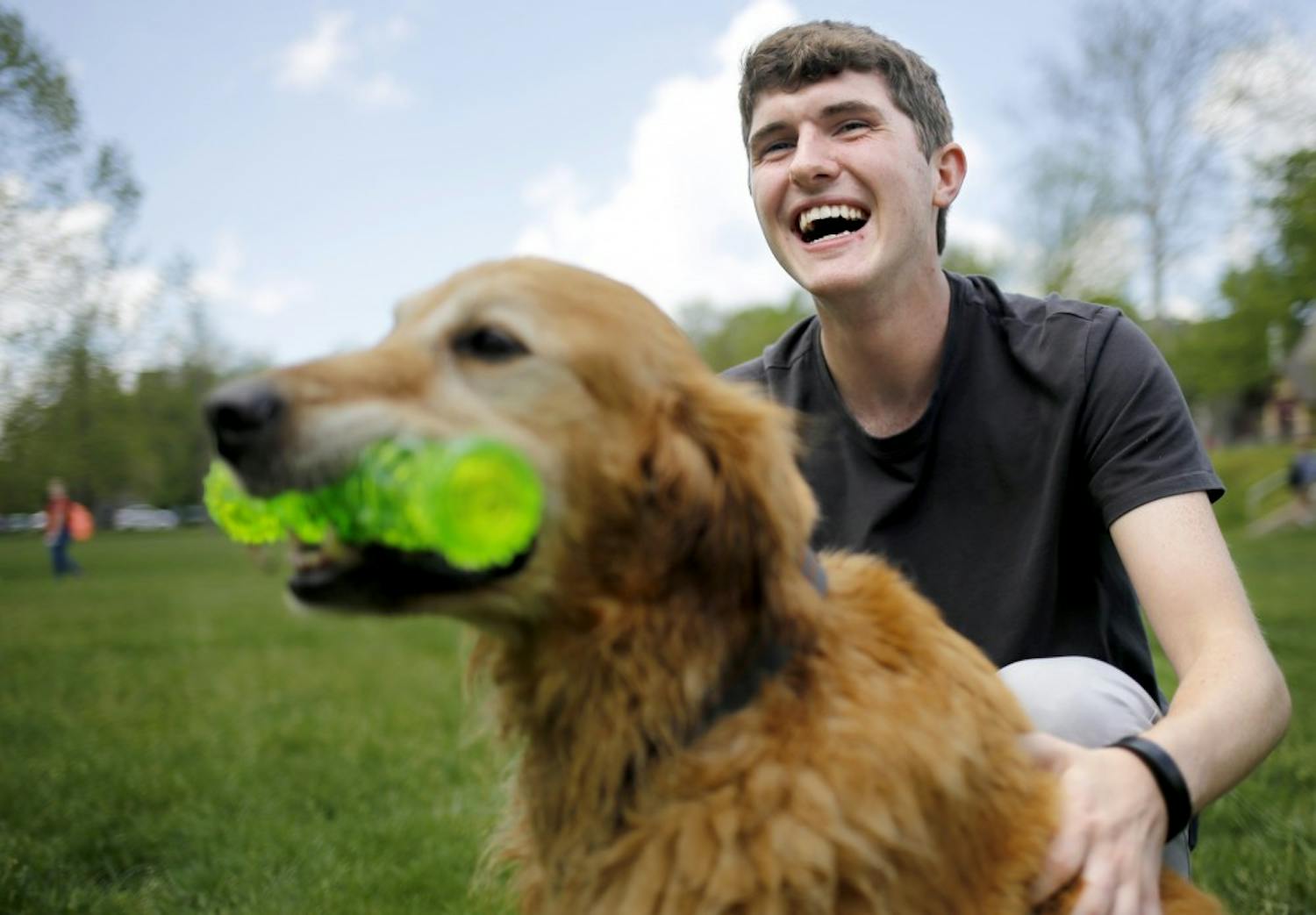 Junior Liam Foran plays with ten-year-old Golden Retriever Max during the Rent-A-Puppy event Thursday at Dunn Meadow. "I've been away from my dogs for too long, and I just needed some puppy love," Foran said. 