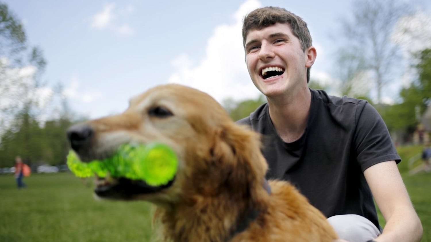 Junior Liam Foran plays with ten-year-old Golden Retriever Max during the Rent-A-Puppy event Thursday at Dunn Meadow. "I've been away from my dogs for too long, and I just needed some puppy love," Foran said. 