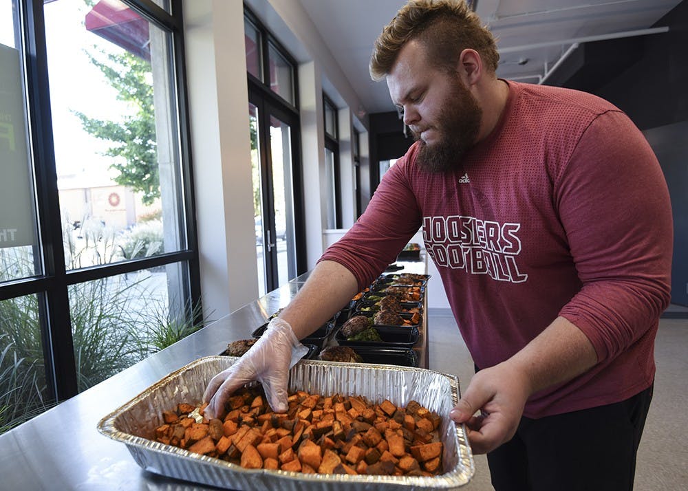 <p>Travis Leonard, assistant kitchen manager, assembles meals in The Fresh Fork on Thursday. The Fresh Fork is a custom meal ordering service that delivers food to Willkie and Eigenmann residence halls and to Bloomingfoods.</p>