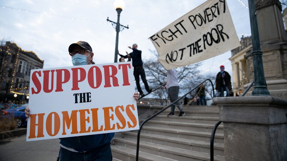 A protester holds a sign that says &quot;Support the Homeless&quot; as others raise a banner Dec. 11, 2020﻿ at the Monroe County Courthouse. Heading Home of South Central Indiana is hoping to launch various programs to fight homelessness in Bloomington.