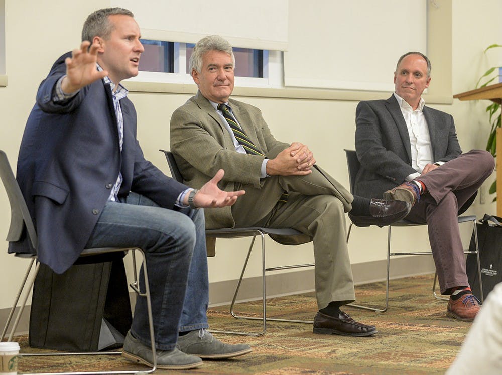 Walter Helmke, middle, and GOP chair Tim Berry listen to DEM chair John Zody talk to students in the Civic Leaders Living-Learning Center on Monday in Briscoe Residence Center. Before the talk, Zody and Berry casually agreed to dress in blue and red as to represent their respective party affiliations.
