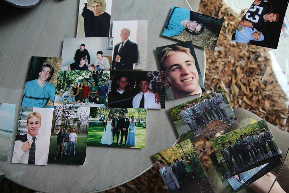 Photos of Caleb, from multiple years, are spread on the glass table in the front room.