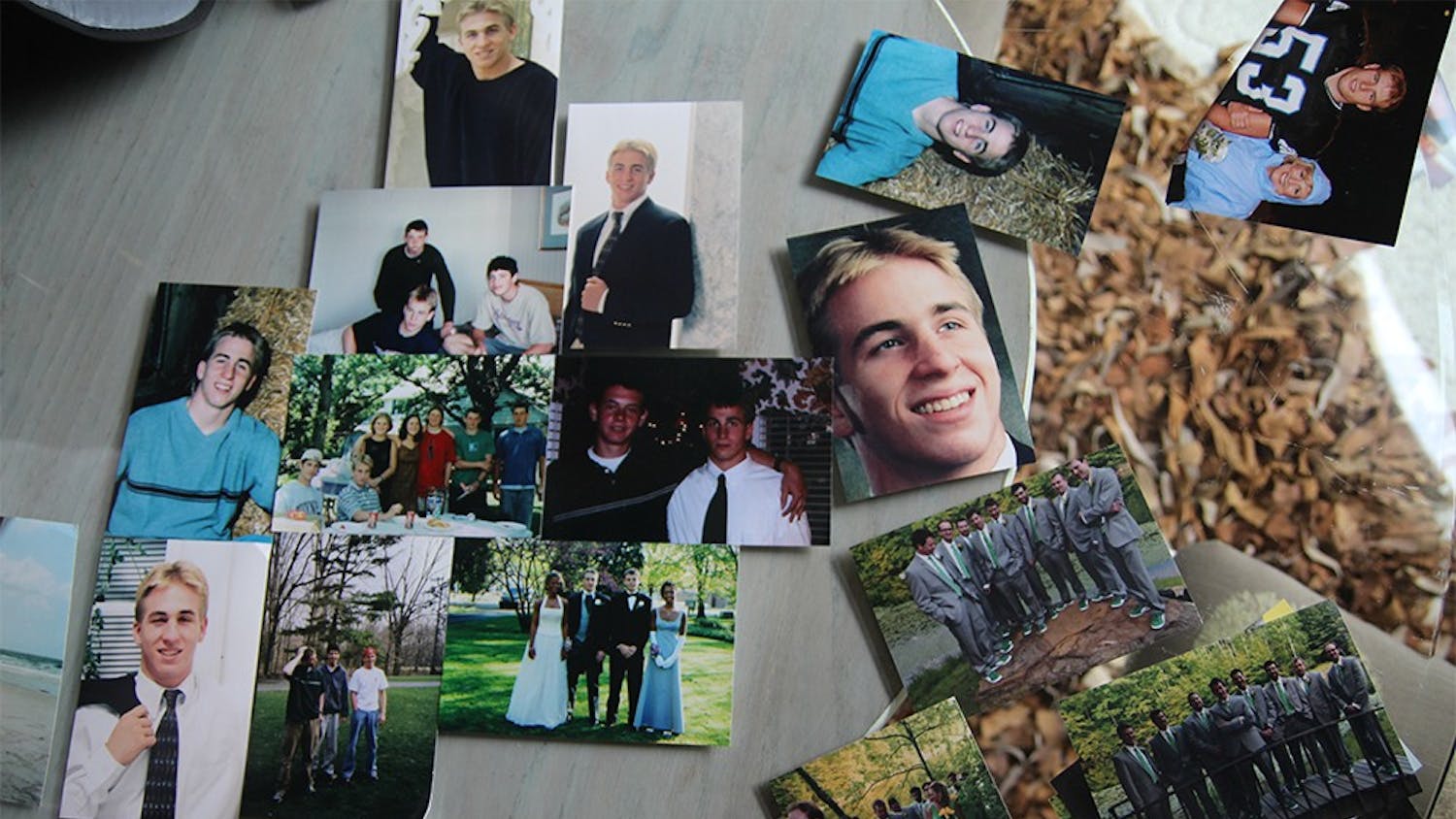 Photos of Caleb, from multiple years, are spread on the glass table in the front room.