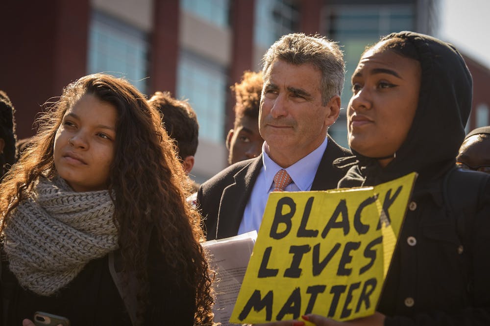 <p>University of Connecticut president Thomas Katsouleas stands with students demonstrating at UConn on Oct. 21. The protest was in response to a recent video showing white students in the Charter Oak apartments parking lot using racial slurs and laughing about it as they walked past black students&#x27; apartments.</p>
