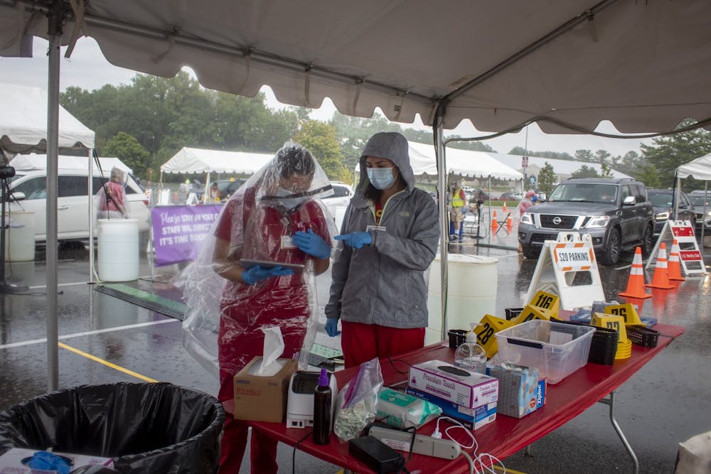 <p>IU students Jessica Gutierrez and Ericka Alvarez work at a COVID-19 testing center Aug. 18, 2020, by Memorial Stadium. IU reported 58 positive test results out of 6,745 mitigation tests Jan. 13.</p>