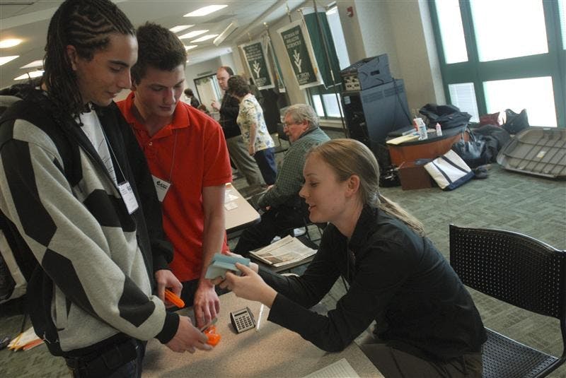 Ivy Tech students,Freshmen Patrick Anderson and Patrick Anderson, pretend to hold up and rob Ivy Tech employee Chelsea Rood. They were renacting a scene as a pawn shop and gun shop worker during a poverty simulation Wednesday afternoon in the Ivy Tech Commons. The simulation included students from Ivy Tech and IU who had to manage the hardships of poverty by juggling their family's sustenance and education, finding and keeping a job, repaying loans, and other scenarios.