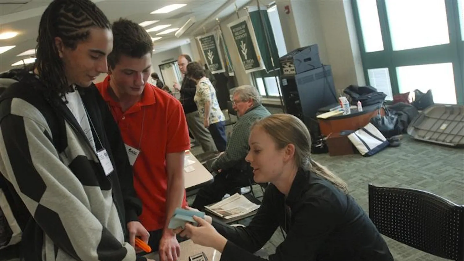 Ivy Tech students,Freshmen Patrick Anderson and Patrick Anderson, pretend to hold up and rob Ivy Tech employee Chelsea Rood. They were renacting a scene as a pawn shop and gun shop worker during a poverty simulation Wednesday afternoon in the Ivy Tech Commons. The simulation included students from Ivy Tech and IU who had to manage the hardships of poverty by juggling their family's sustenance and education, finding and keeping a job, repaying loans, and other scenarios.