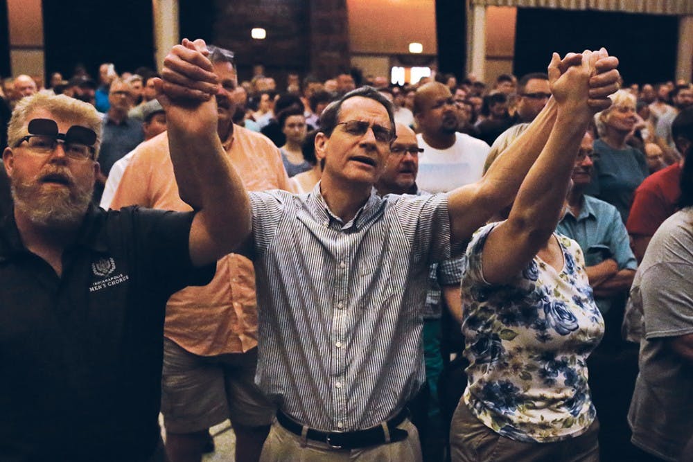 Jim Higginbotham raises his arms during a performance and sings the lyrics, "Hallelujah" along with the singer during a vigil, which took place in the Egyptian Room at the Old National Centre Sunday evening and was sponsored by Indy Pride in response to the recent mass shooting that took place at a gay night club in Orlando, Florida. 