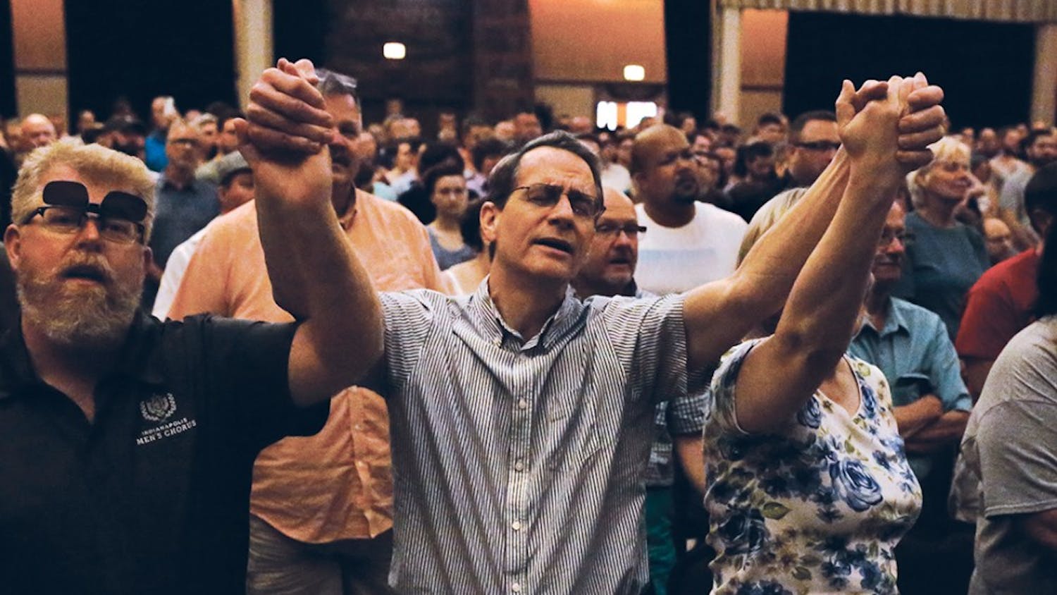 Jim Higginbotham raises his arms during a performance and sings the lyrics, "Hallelujah" along with the singer during a vigil, which took place in the Egyptian Room at the Old National Centre Sunday evening and was sponsored by Indy Pride in response to the recent mass shooting that took place at a gay night club in Orlando, Florida.