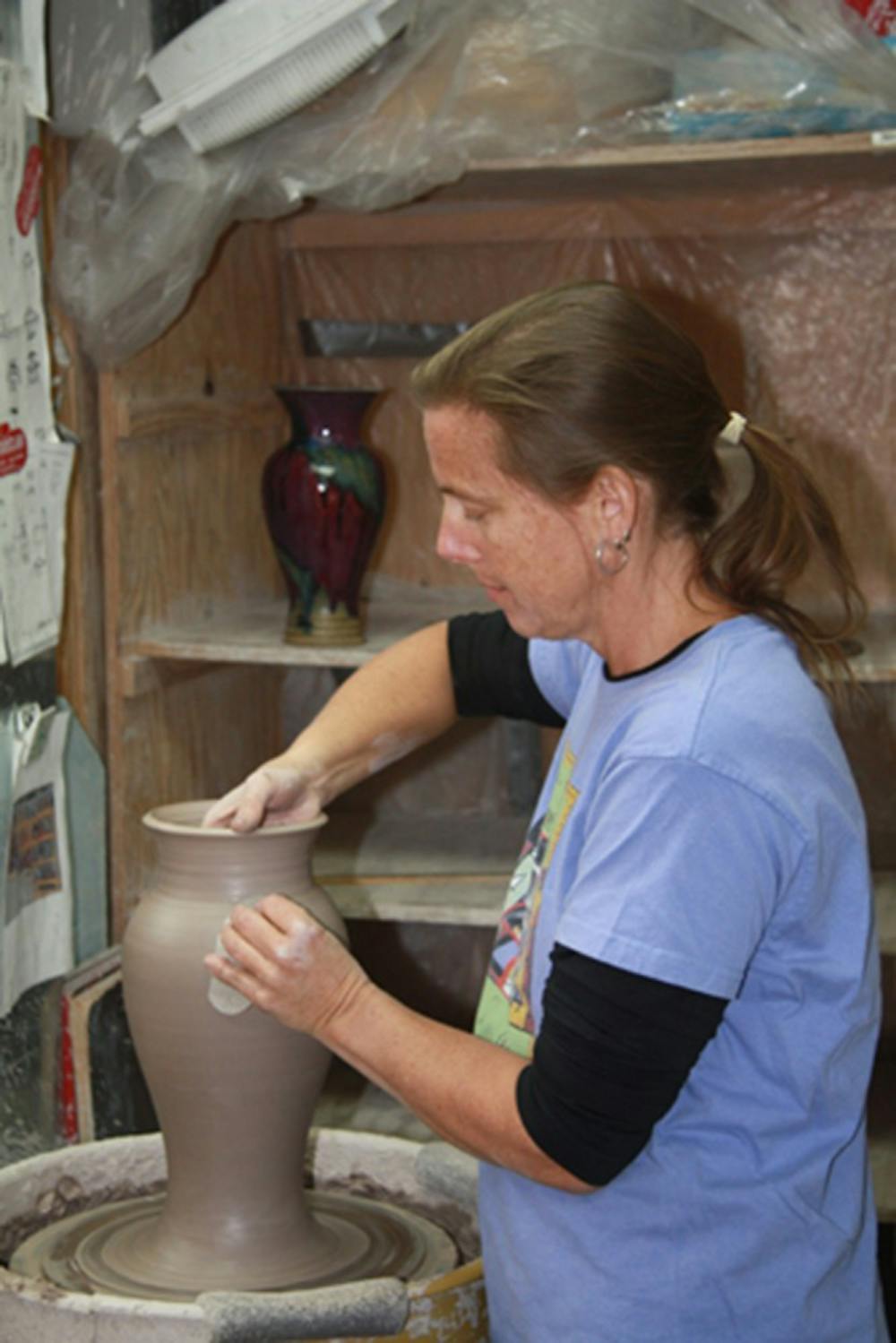 Kris Busch works on a pottery wheel before the Artisan Guild show. The Artisan Guild is currently preparing for a show at the Bloomington Convention Center on Friday from 4 p.m. to 9 p.m.