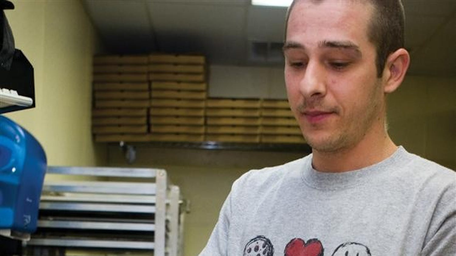 Pizza Express employee John Reidy puts the final touches on a pizza before putting it in the oven Thursday, May 3, 2007 at the Pizza Express on East Tenth Street.