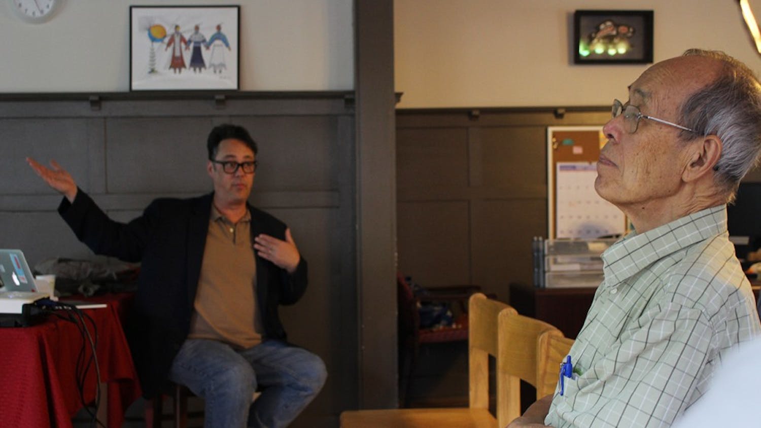 Chinese calligrapher James Yang listens intently to Jason Jackson discuss his trips to China at the First Nations Educational and Cultural Center. Yang is an artist working with the Mathers Museum of World Cultures who would love to visit China as well.