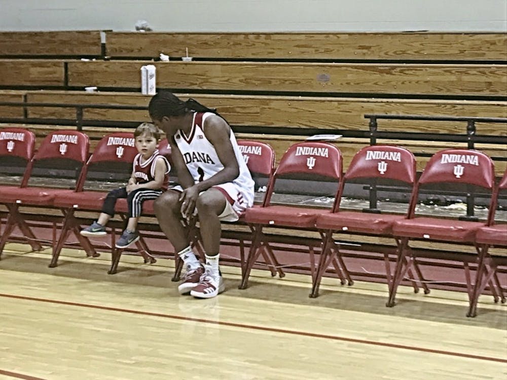 Sophomore IU women's basketball guard Bendu Yeaney sits on the bench and talks with Brayden Wierzba at Simon Skjodt Assembly Hall. Wierzba is the son of assistant women's basketball Coach Rhet Wierzba.&nbsp;