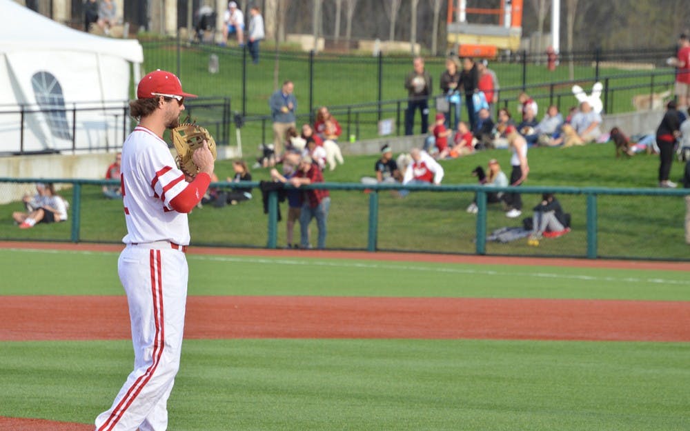 Sophomore Luke Miller dusts off his glove after stopping a ground ball Tuesday evening during IU's game against Ball State. Miller had a 6-RBI weekend against the Michigan Wolverines.