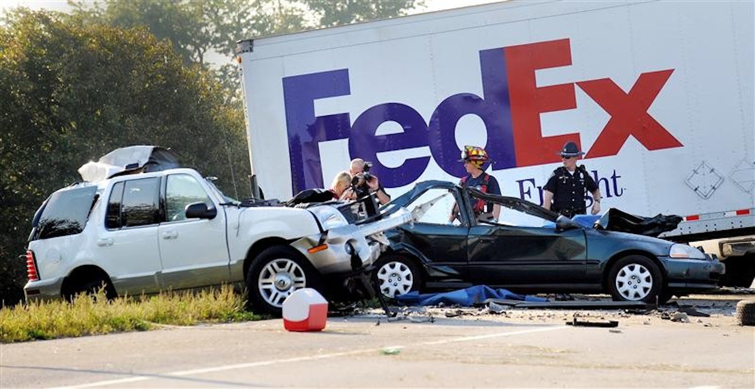 Indiana State Police and Johnson County emergency response personnel investigate a double fatal accident on Thursday on northbound Interstate 65 near Whiteland, Ind. The accident happened early Thursday morning when the FedEx truck lost its tandem trailer, crossed the median and slammed into a three cars killing two. State police say two other people were injured.