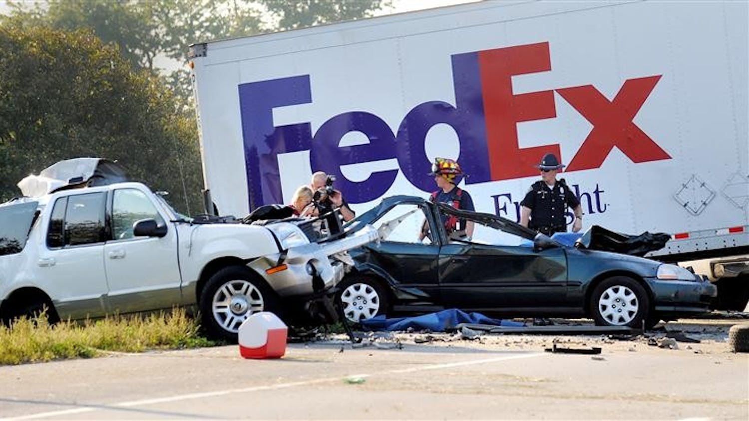 Indiana State Police and Johnson County emergency response personnel investigate a double fatal accident on Thursday on northbound Interstate 65 near Whiteland, Ind. The accident happened early Thursday morning when the FedEx truck lost its tandem trailer, crossed the median and slammed into a three cars killing two. State police say two other people were injured.