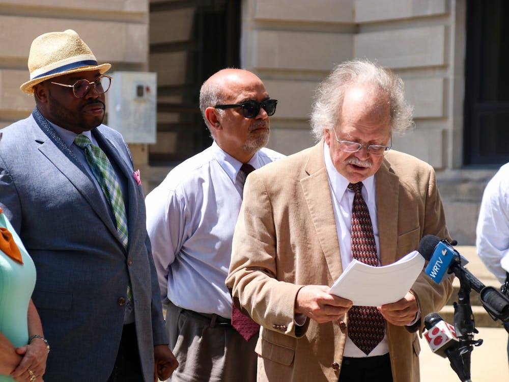周一，全国有色人种进步协会门罗县分会法律补救委员会主席盖伊·洛夫曼在门罗县法院门前对媒体发表讲话。大约24人聚集在一起支持沃克斯·布克。