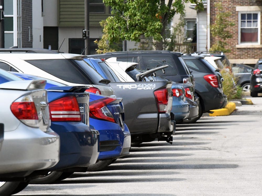 Parked cars are lined up in a parking lot on East Sixth Street. IU employees now have the option to purchase multiyear parking permits.