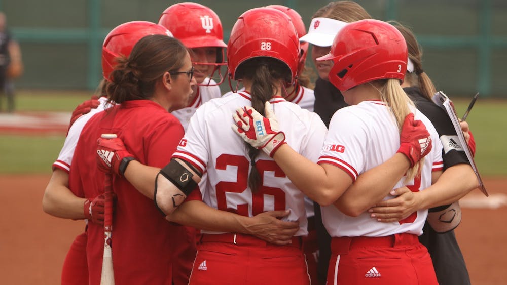 IU softball team members and coaches join for a huddle April 24, 2022, at Andy Mohr Field. Indiana will compete in the UNCG Invitational this weekend.