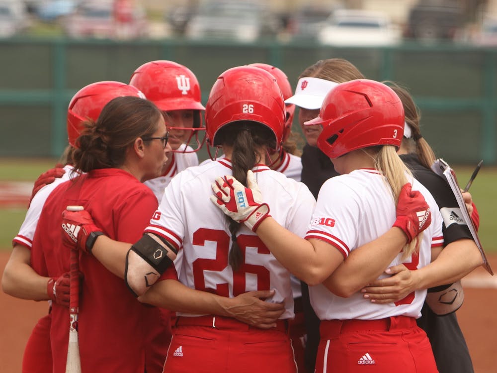 IU softball team members and coaches join for a huddle April 24, 2022, at Andy Mohr Field. Indiana will compete in the UNCG Invitational this weekend.