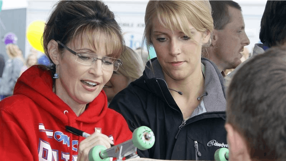 Alaska Gov. Sarah Palin, left, signs a skateboard during the governor's picnic in Wasilla, Alaska Friday, July 24, 2009.  This is one of three governor's picnics Palin is attending before she resigns as governor in Fairbanks on Sunday, July 26, 2009. 