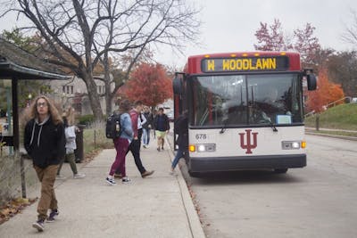 Students get on a campus bus Nov. 5 on E. 7th St. IU bus services are working together with a transportation planning firm to improve the bus routes.