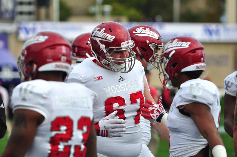 Senior lineman Dan Feeney greets his teammates as he joins warmups on Saturday before IU's game against Northwestern at Ryan Field.