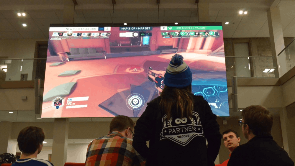 Members of IU's esports team gather in Franklin Hall to attend the Winter Esports Expo. On the large screen in the Media Commons of Franklin Hall, professional esports teams from New York City and Los Angeles battle it out in the video game "Overwatch."