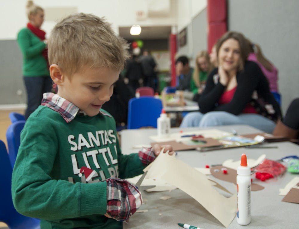 <p>Four-year-old Parker Foust cuts paper to make a reindeer craft during Breakfast with Santa in 2013 at the YMCA. The YMCA had to shut down their childcare program because they could no longer afford the financial subsidies required to remain a licensed child care center.</p>