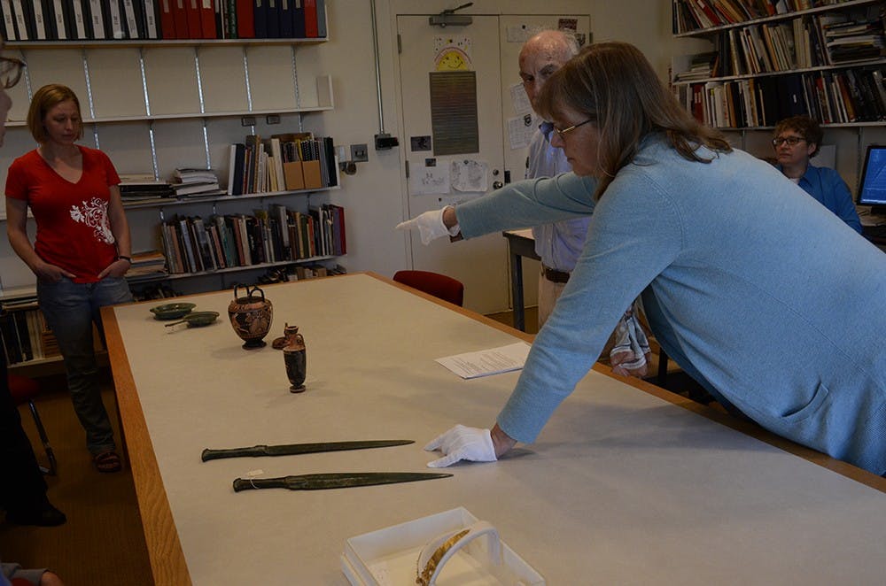 Juliet Istrabadi, acting curator of ancient art for IU Art Museum, tells the audience unique stories of the ancient subjects that are displayed on the table on Friday. 