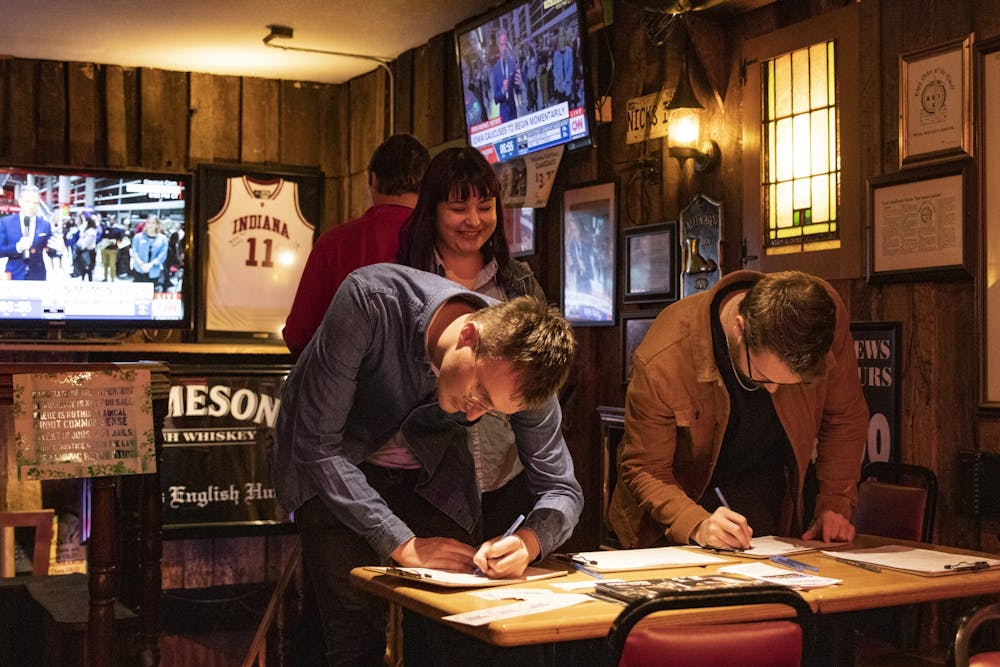<p>IU second year law students Alex Busse and Matt Ritter sign Iowa Caucus watch party attendance sheets Feb. 3 at Nick’s English Hut. “I am feeling the Bern,” Busse said.</p>