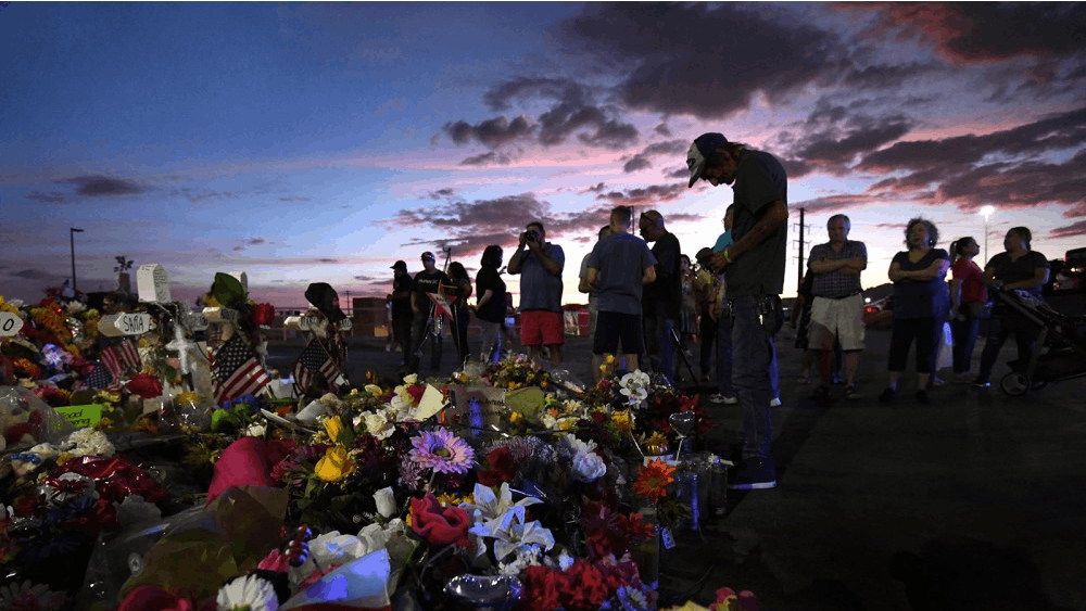 Antonio Basco stands silently at his wife&#x27;s cross as family members visit the memorial site at dusk after funeral services that day for Walmart mass shooting victim Margie Reckard on Aug. 17 in El Paso, Texas.