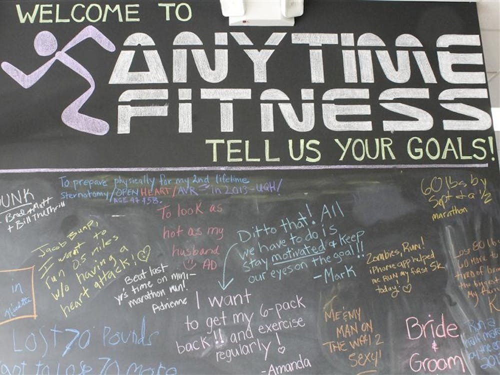 Members' fitness goals for the new year are scribbled across a chalkboard wall at the Anytime Fitness gym. 

